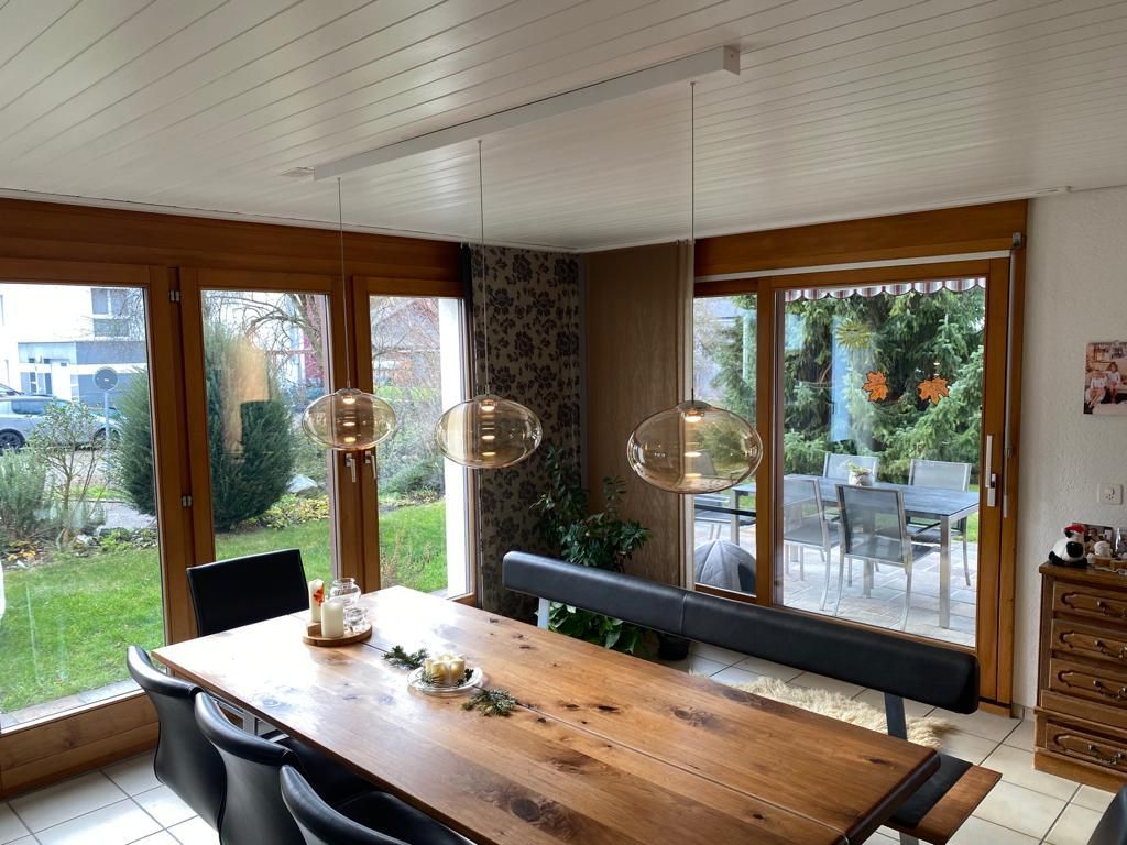 Ein Esszimmer mit einem langen Holztisch und Stühlen.