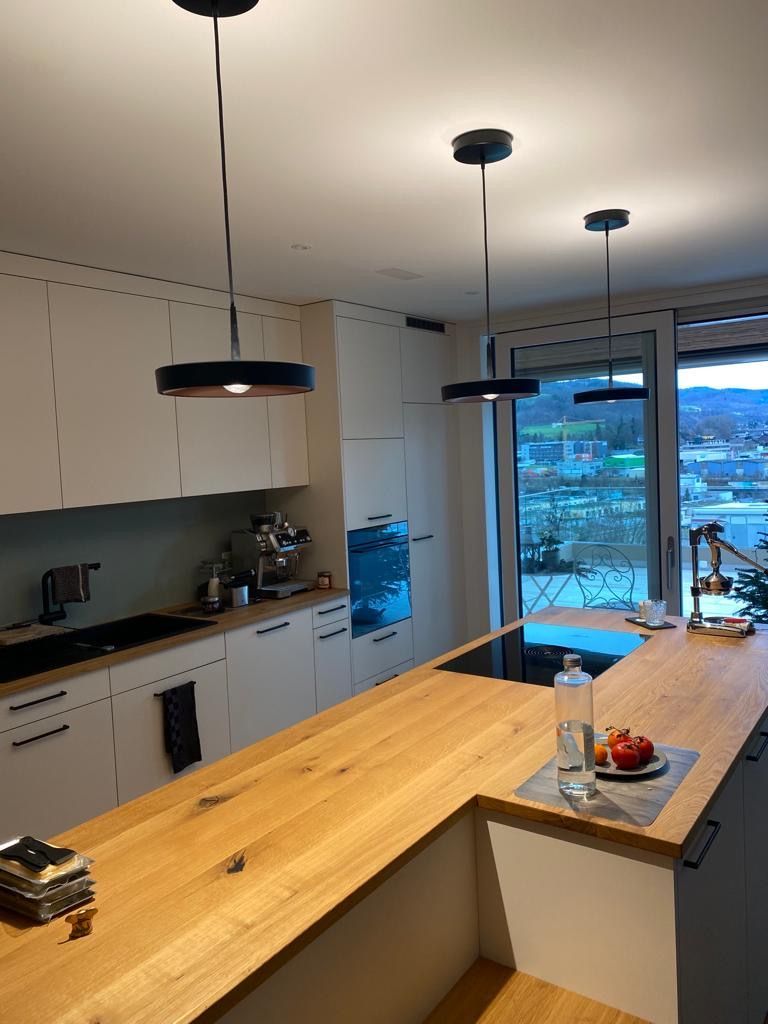 Eine Küche mit weißen Schränken und einer Holzarbeitsplatte.