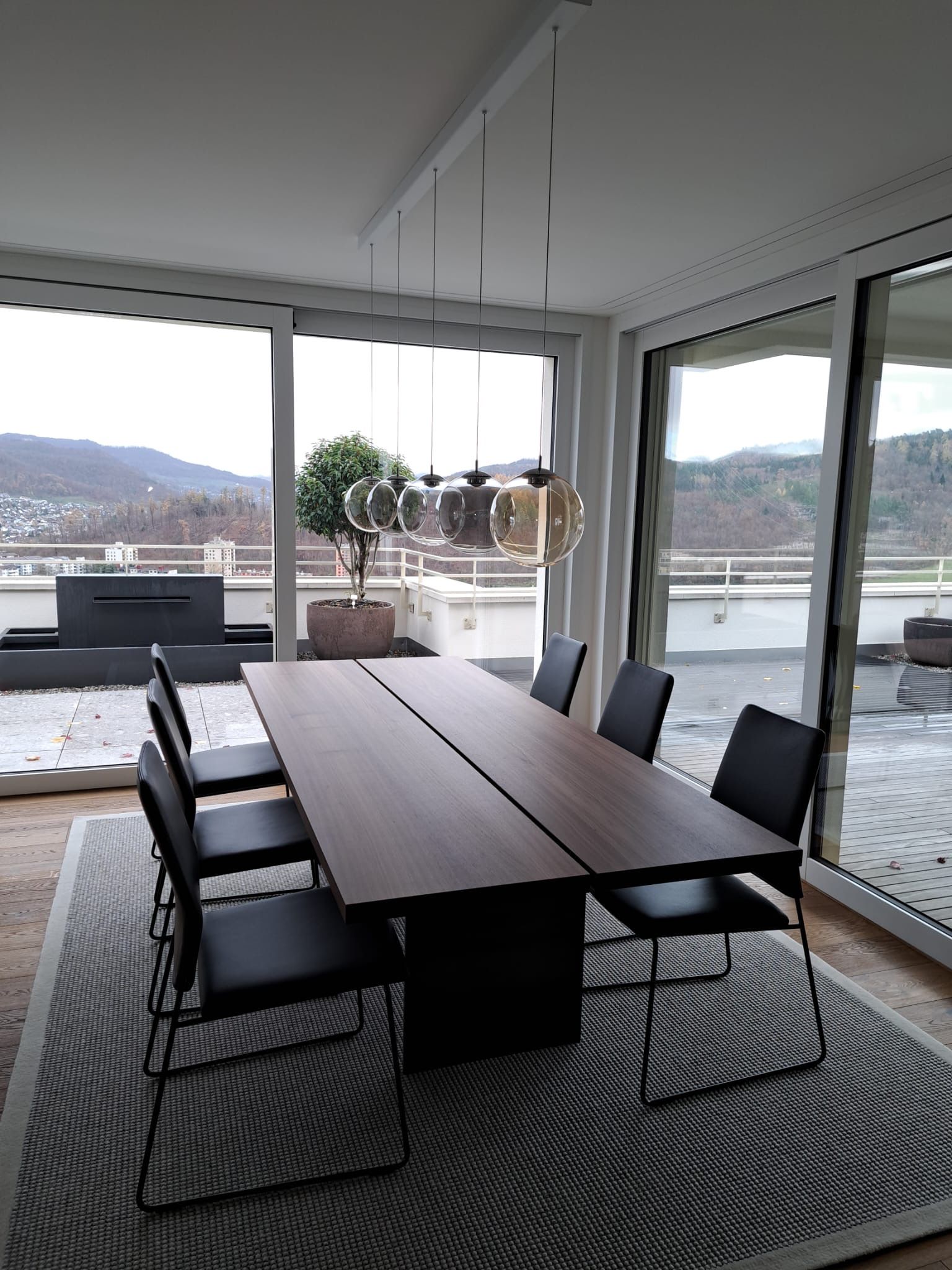 Ein Esszimmer mit Tisch und Stühlen und einem großen Fenster.