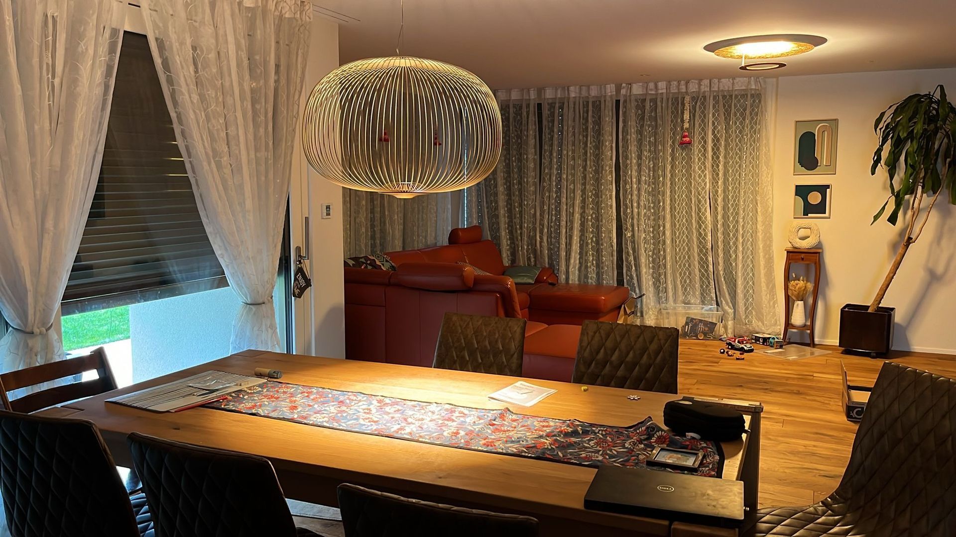 Ein Esszimmer mit Tisch und Stühlen und einem Kronleuchter, der von der Decke hängt.