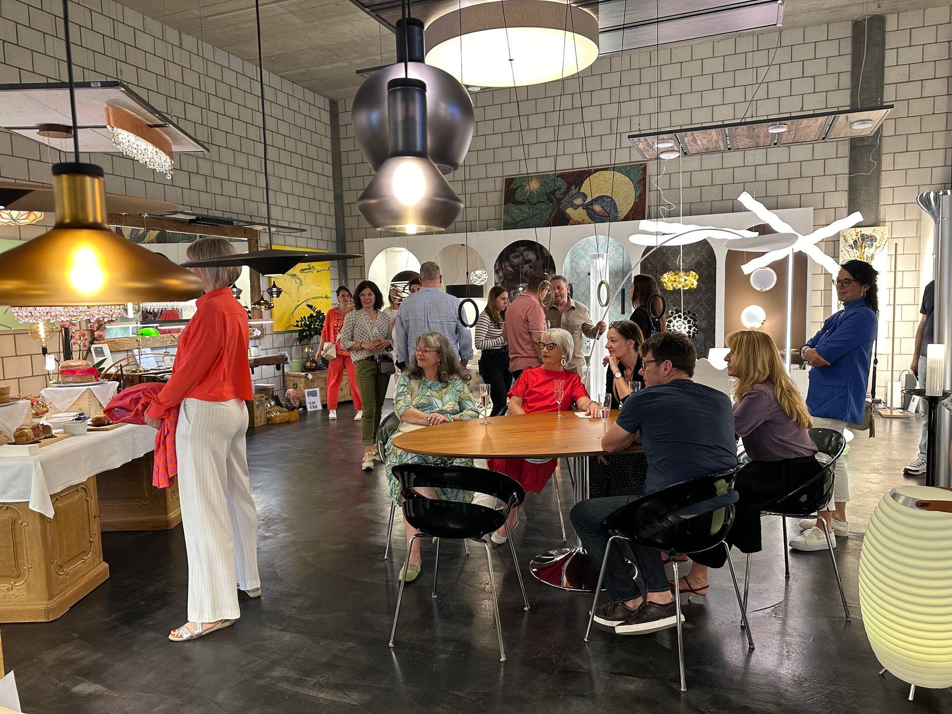 Eine Gruppe von Leuten sitzt in einem Raum an Tischen.