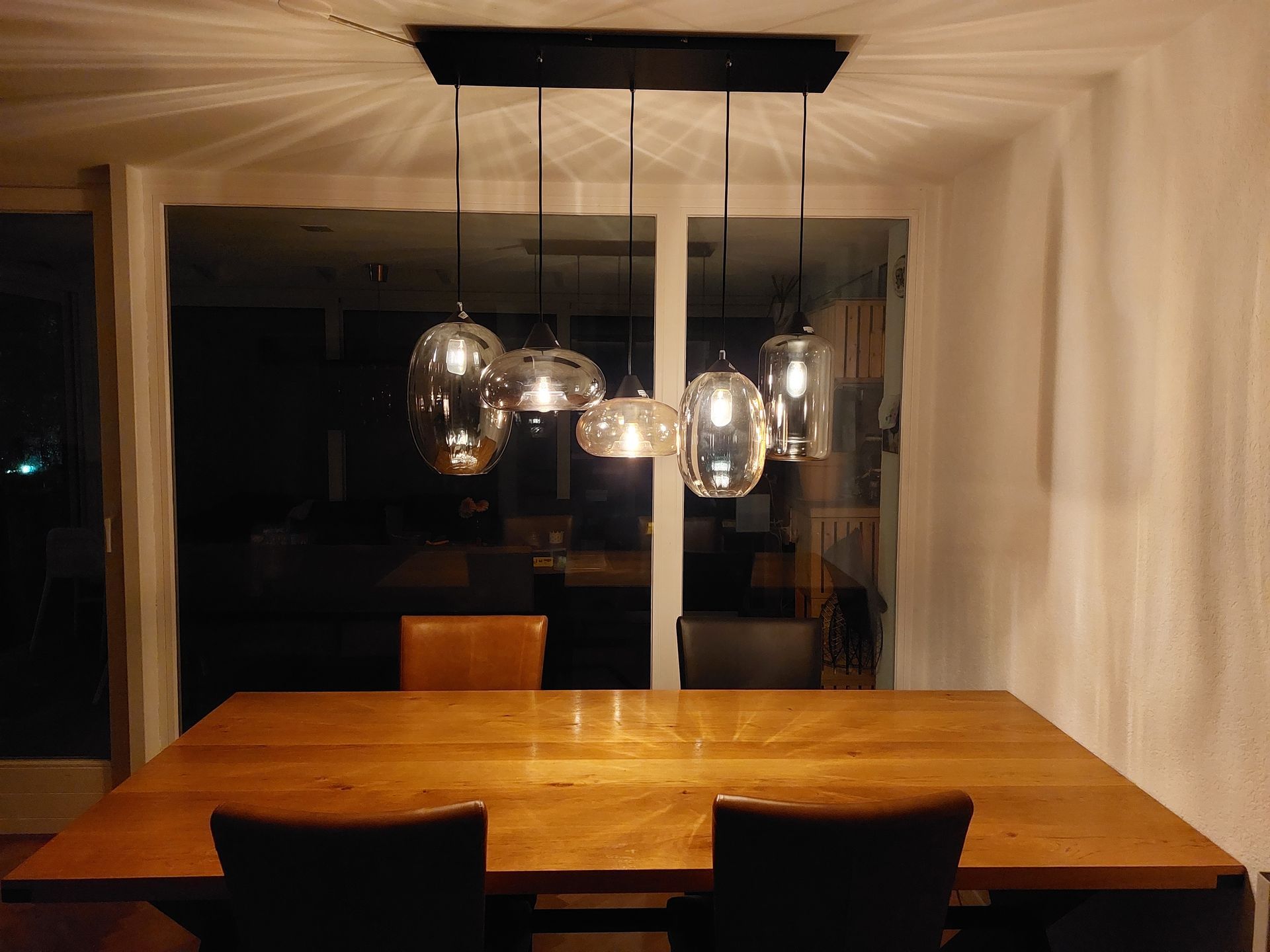 Ein Esstisch mit vielen Lichtern, die von der Decke hängen