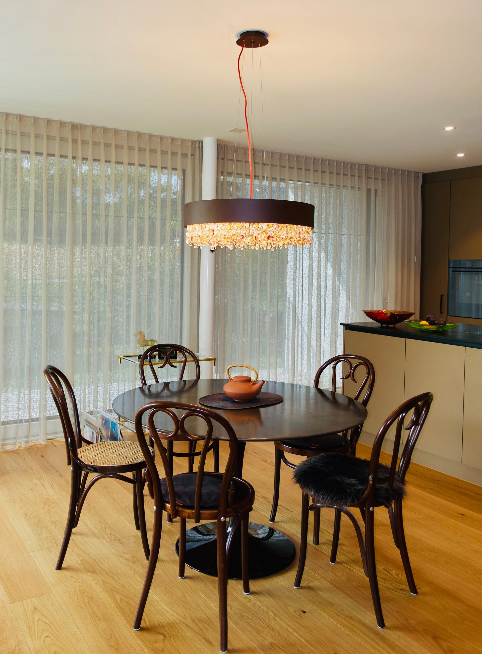 Ein Esszimmer mit Tisch und Stühlen unter einem Kronleuchter