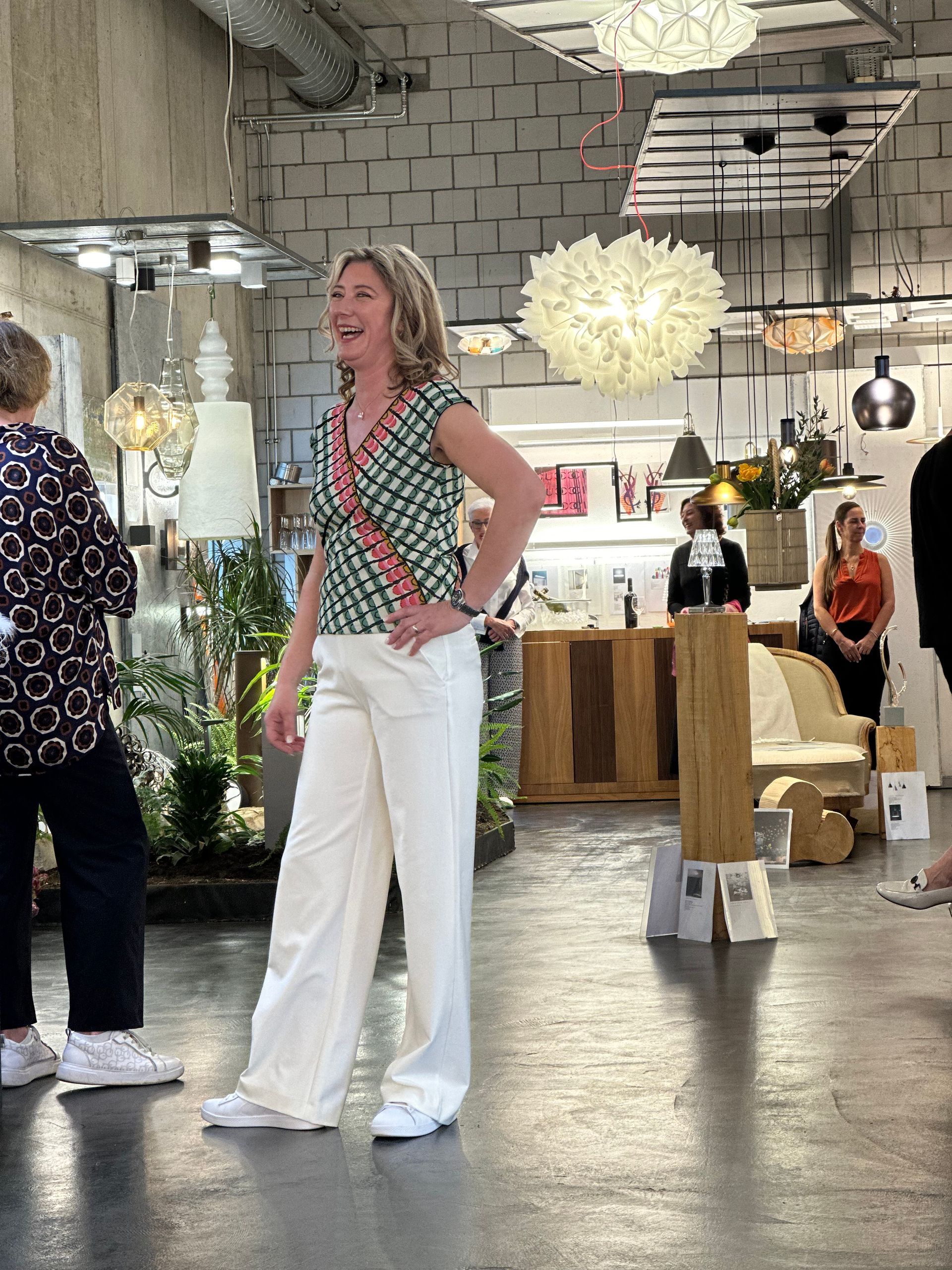 Eine Frau steht mit den Händen in den Hüften in einem Geschäft.