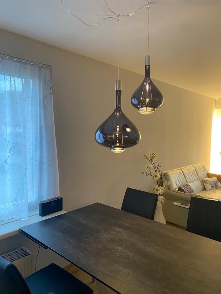 Ein Esstisch mit zwei Pendelleuchten, die von der Decke hängen.