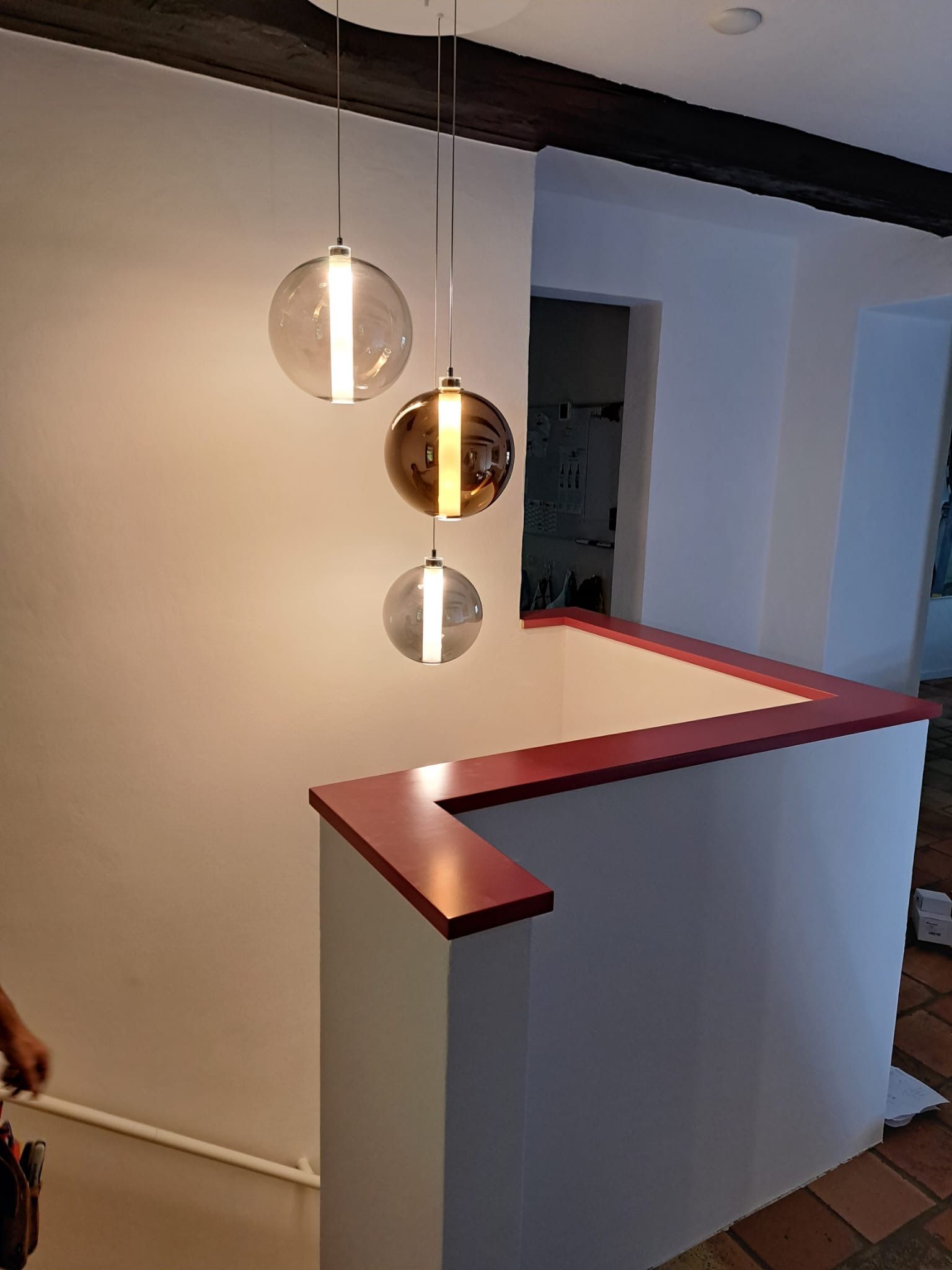 Eine Treppe mit drei Pendelleuchten, die von der Decke hängen.