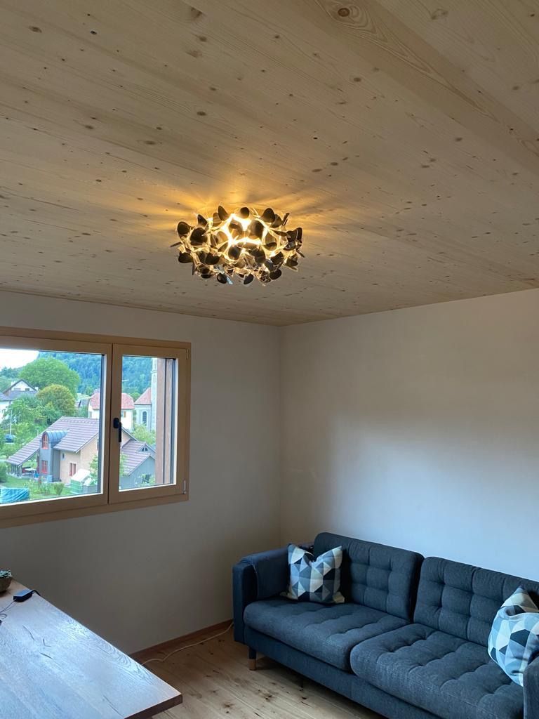 Ein Wohnzimmer mit Couch, Tisch und Fenster.