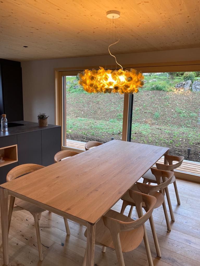 Ein Esszimmer mit einem Holztisch und Stühlen und einem Kronleuchter, der von der Decke hängt.