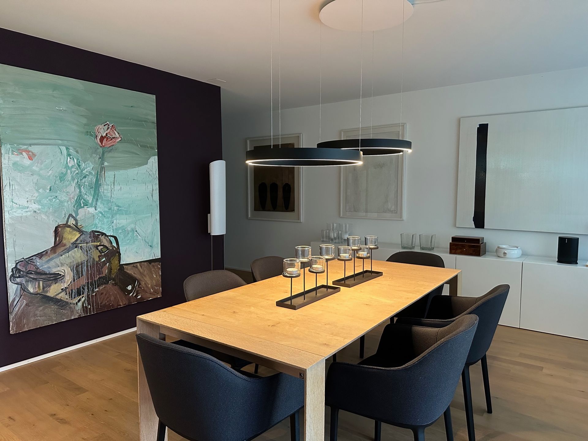 Ein Esszimmer mit Tisch und Stühlen und einem Gemälde an der Wand