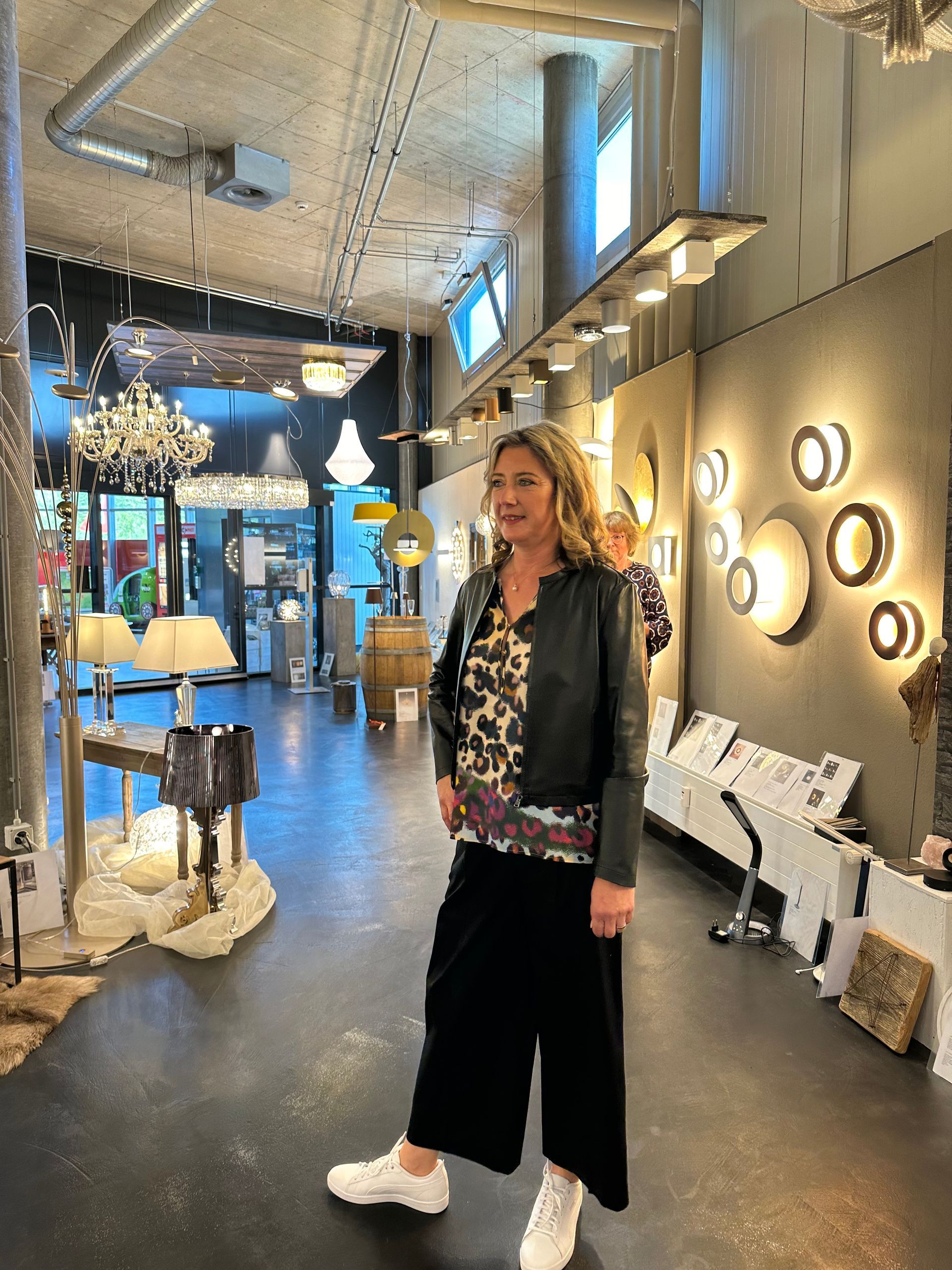 Eine Frau in einer Lederjacke steht in einem Geschäft.