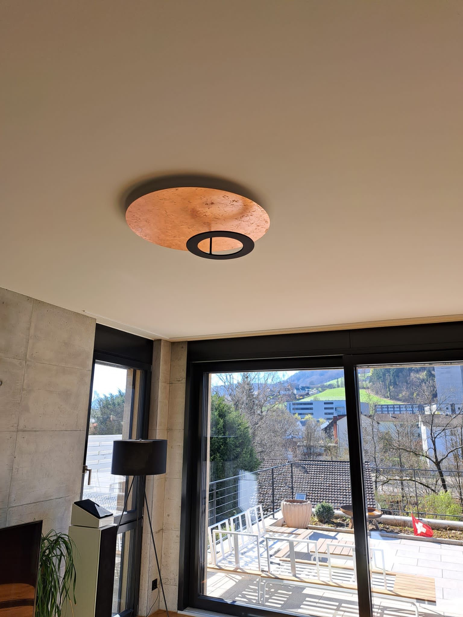 Ein Wohnzimmer mit Deckenleuchte und Glasschiebetür.