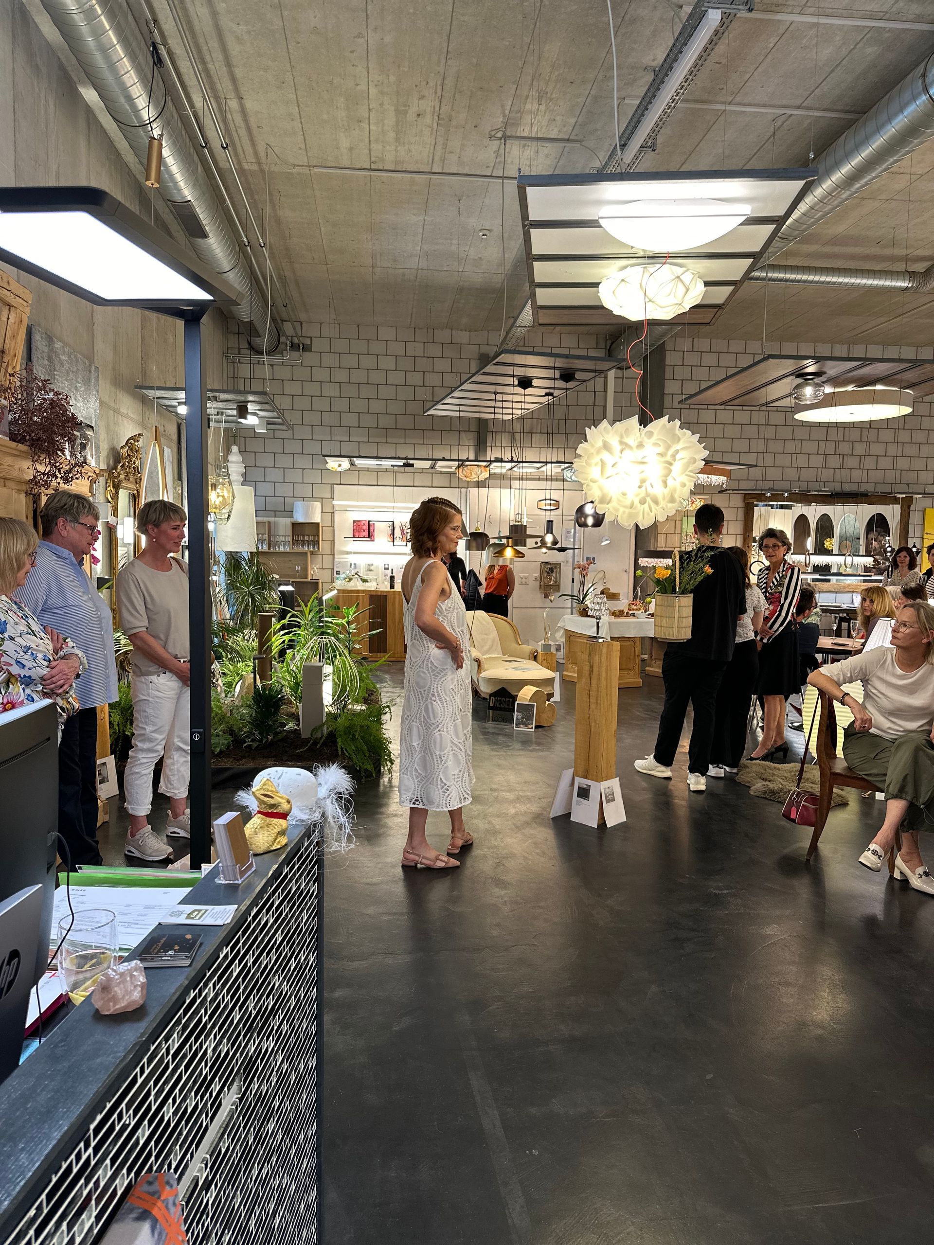 Eine Gruppe von Menschen steht und sitzt in einem großen Raum.