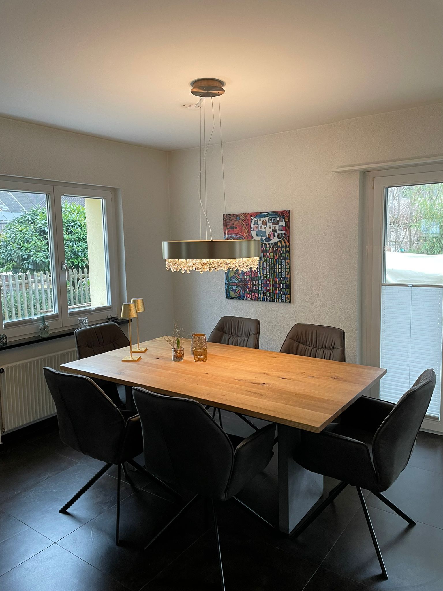 Ein Esszimmer mit einem Holztisch und Stühlen und einem Gemälde an der Wand.