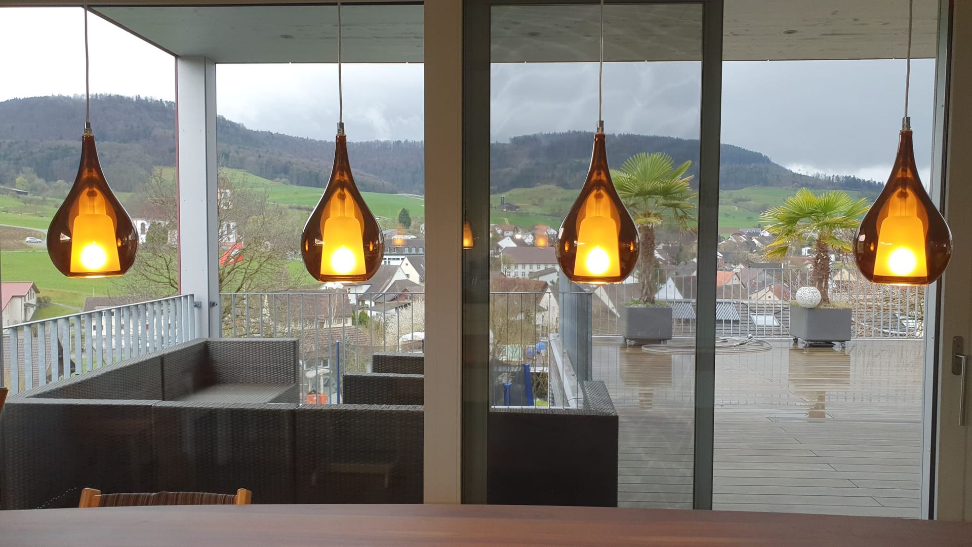 Ein Esszimmer mit Blick auf einen Balkon und die Berge.