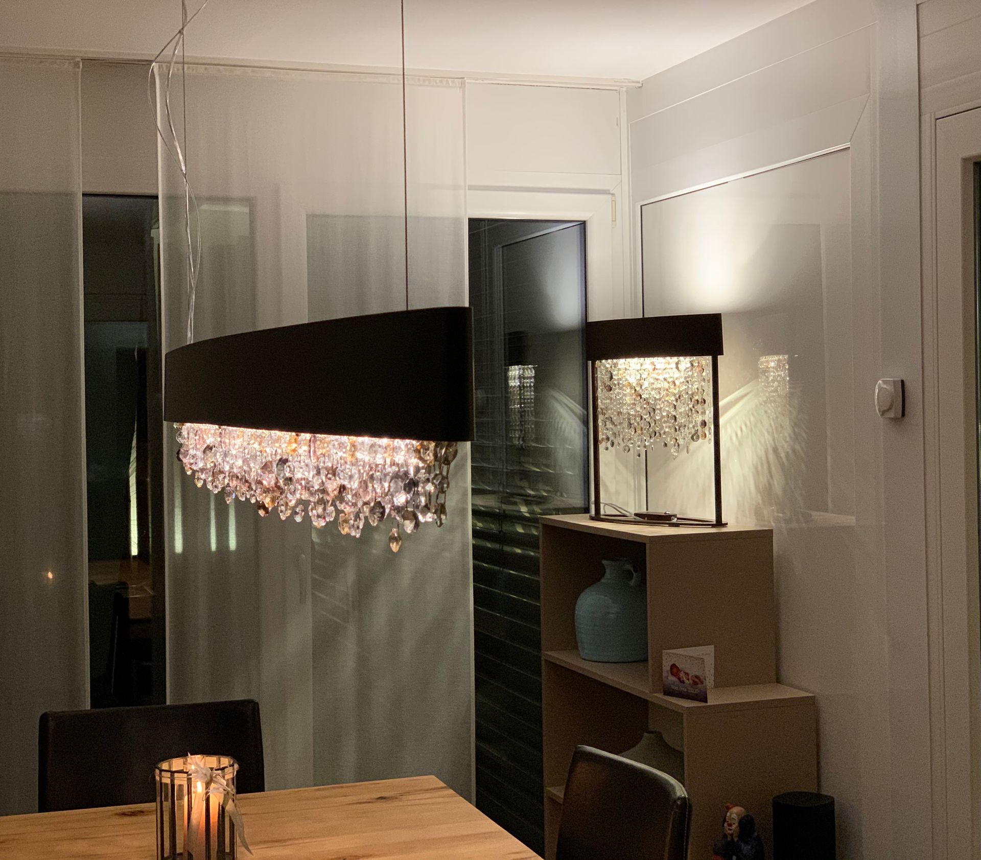 Ein Esszimmer mit Tisch und Stühlen und einem Kronleuchter, der von der Decke hängt