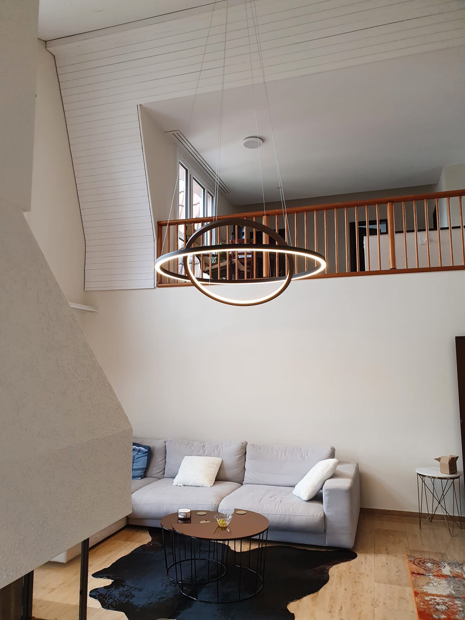 Ein Wohnzimmer mit einer Couch, einem Couchtisch und einem Kronleuchter, der von der Decke hängt.