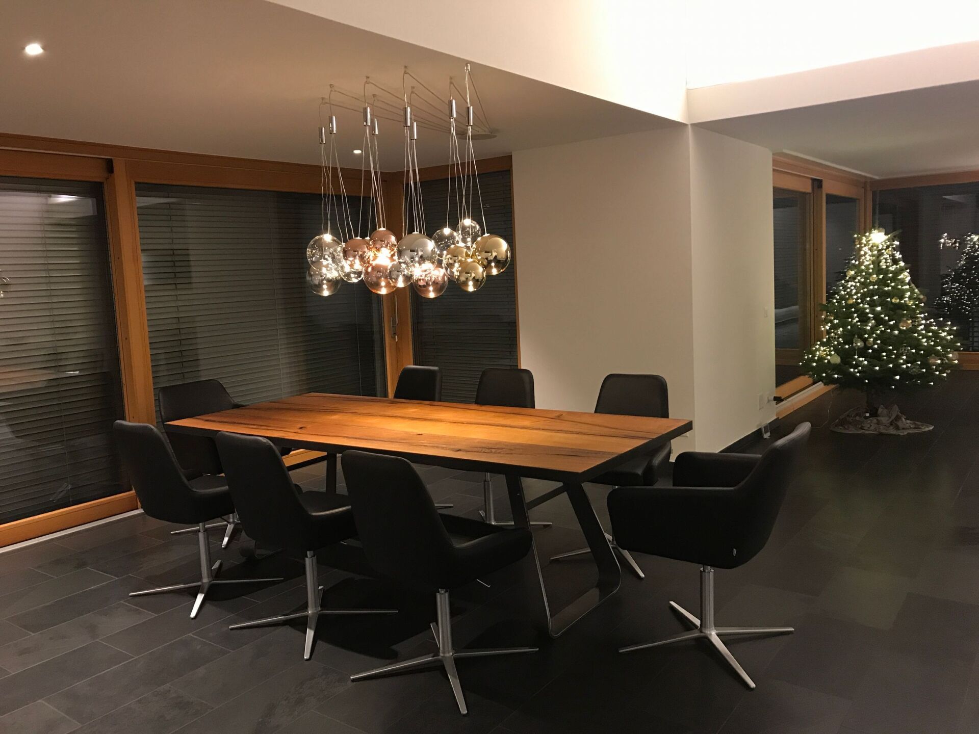 Ein Esszimmer mit einem Tisch und Stühlen und einem Weihnachtsbaum im Hintergrund.