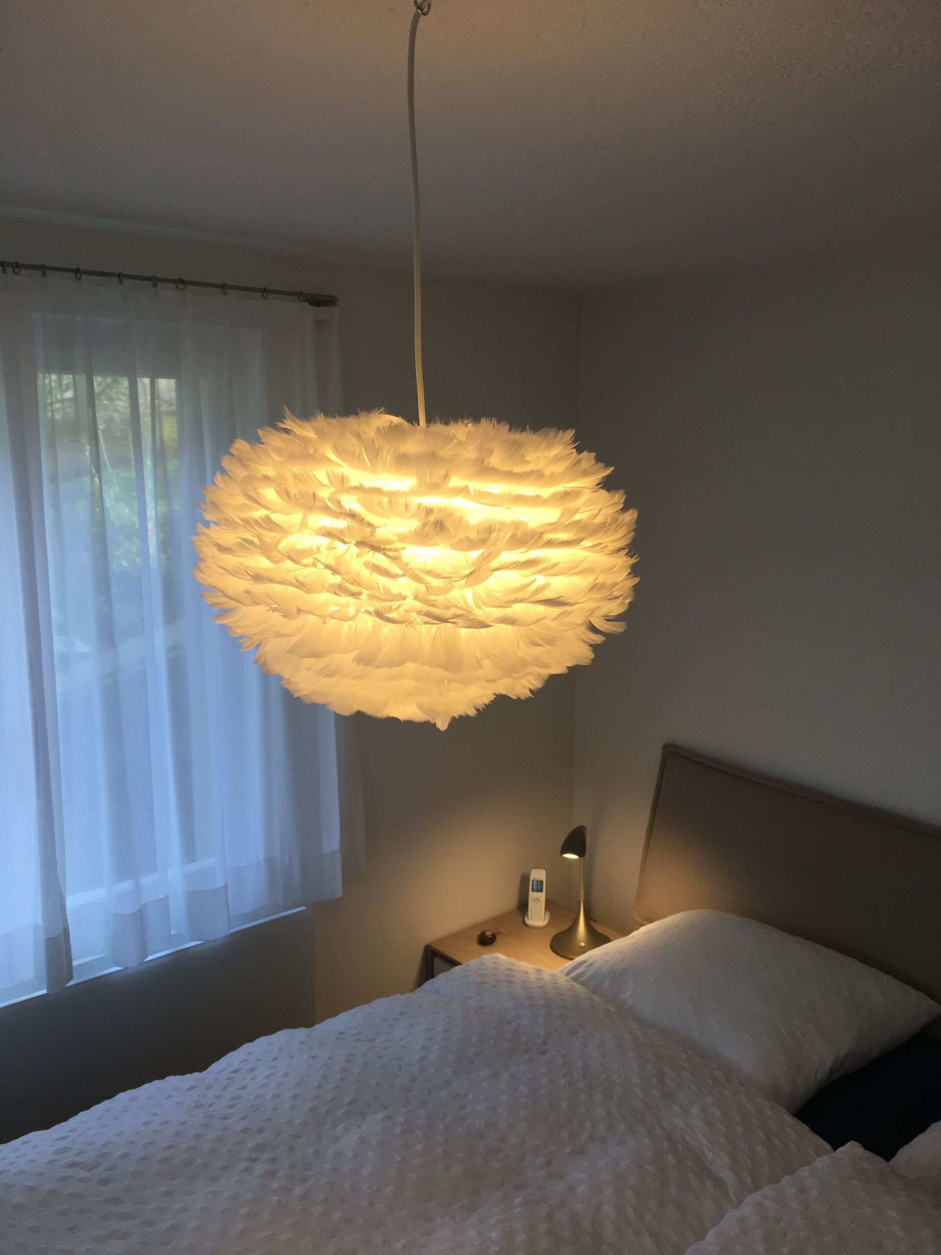 Ein Schlafzimmer mit einem Bett und einer von der Decke hängenden Lampe