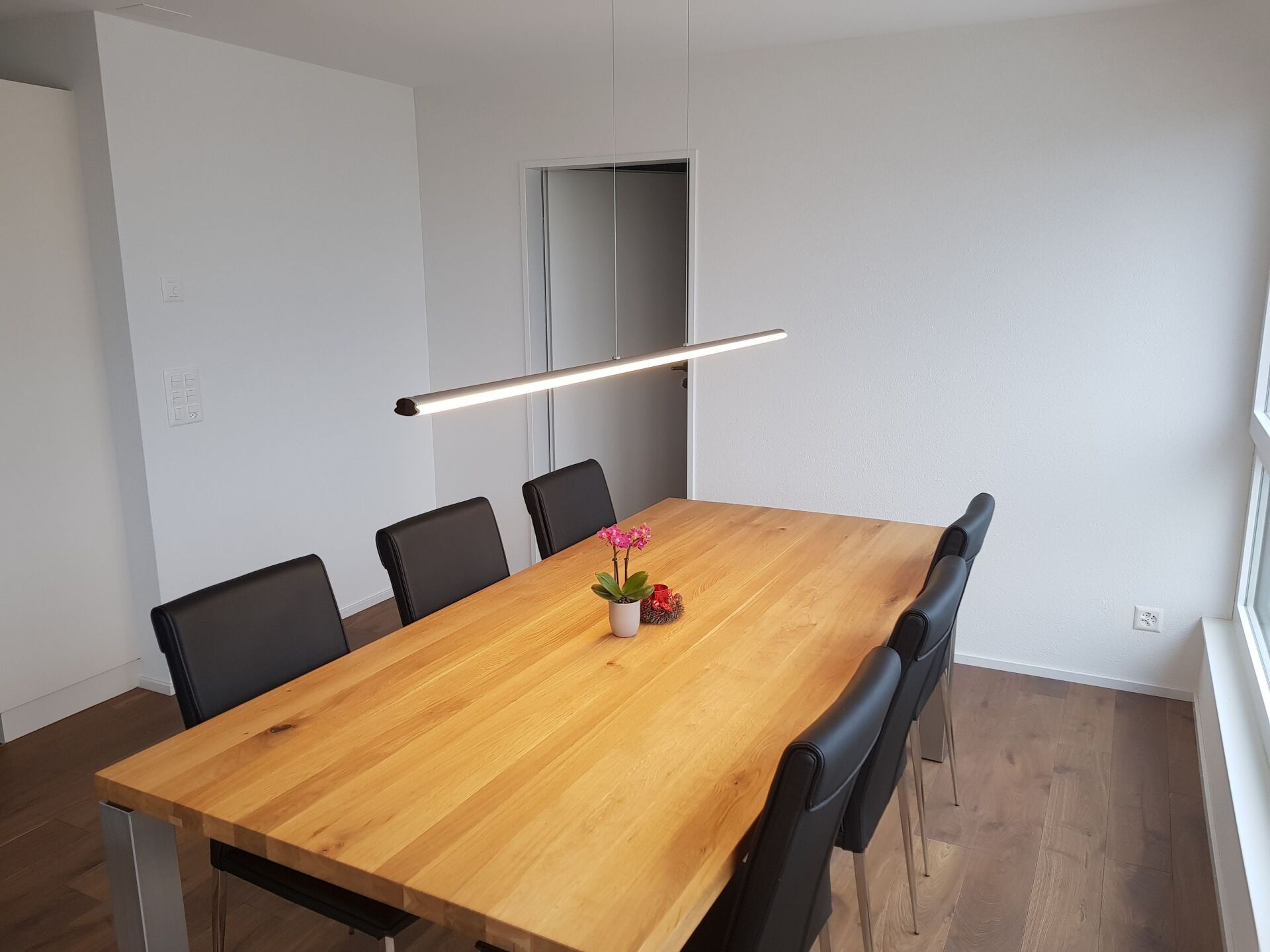 Ein Esszimmer mit einem langen Holztisch und Stühlen