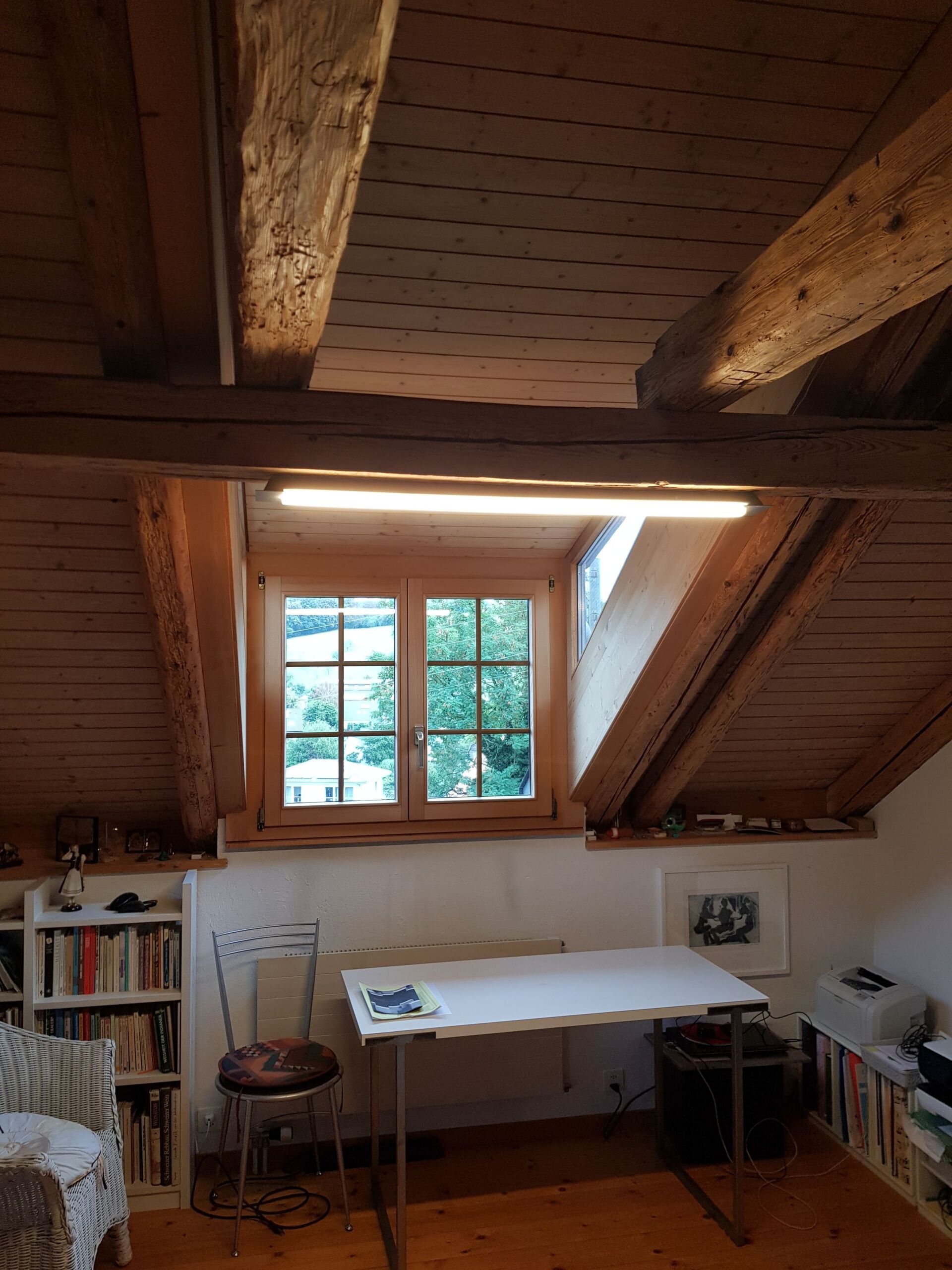 Ein Raum mit einem Tisch und Stühlen und einem Fenster