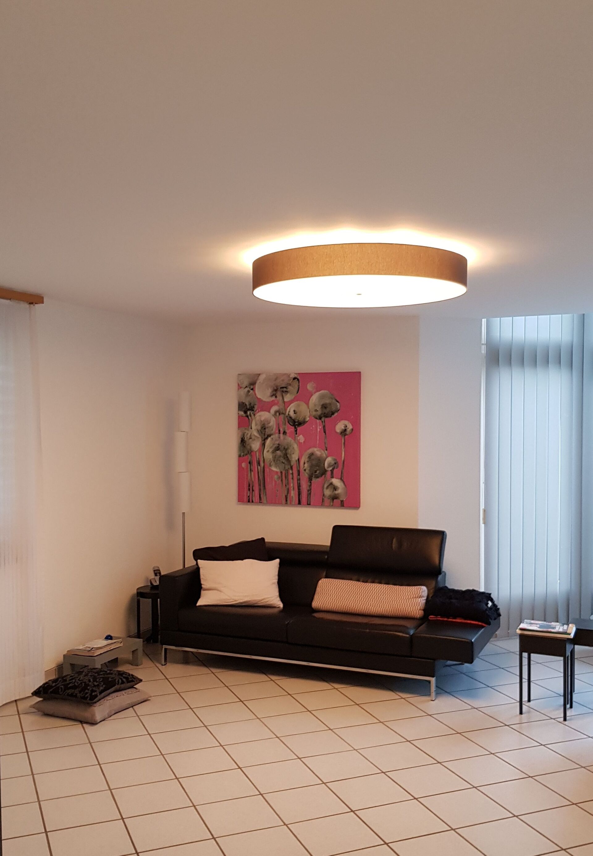 Ein Wohnzimmer mit einer Couch und einem Gemälde an der Wand.