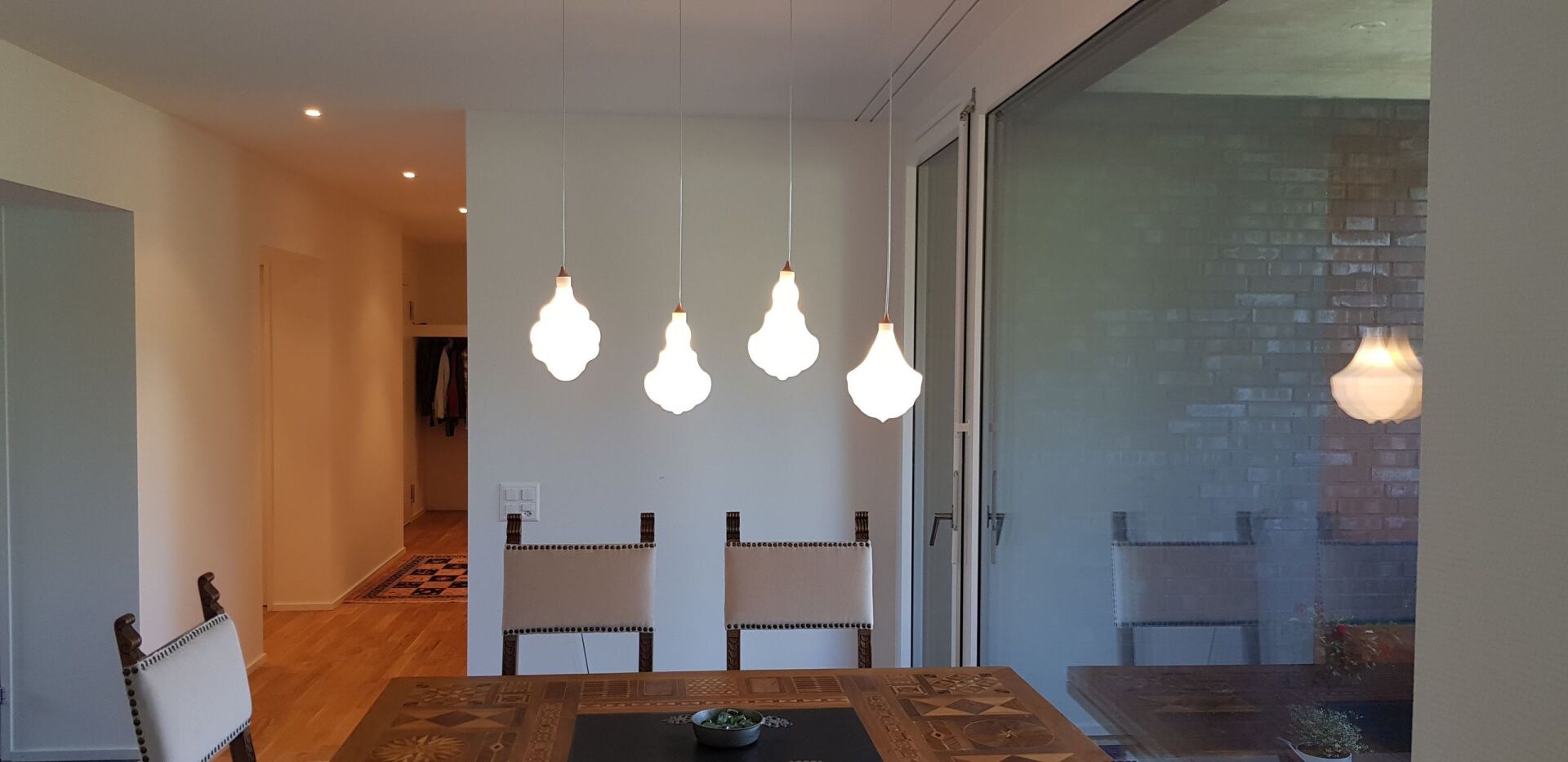 Ein Esszimmer mit Tisch und Stühlen und einer Glasschiebetür.