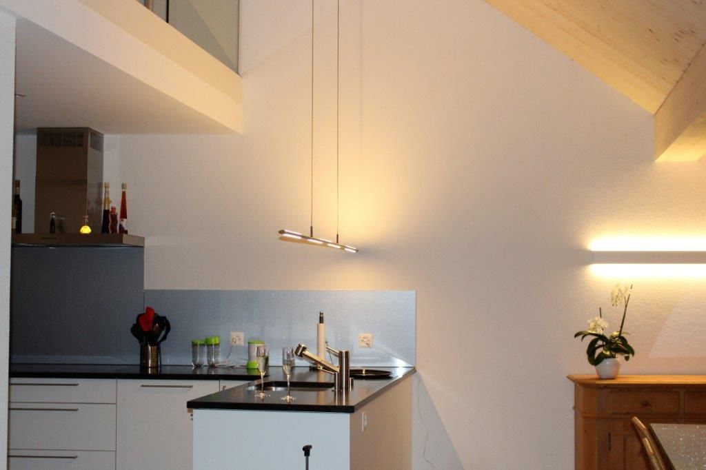 Eine Küche mit weißen Schränken und schwarzen Arbeitsplatten