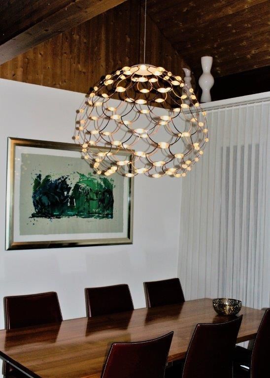 Ein Esszimmer mit Tisch und Stühlen und einem Bild an der Wand