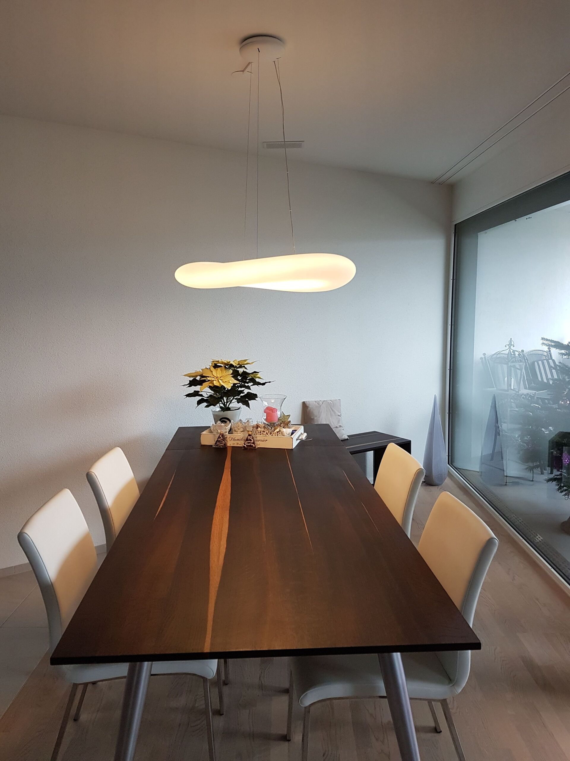 Ein Esstisch mit einer Vase mit Blumen darauf