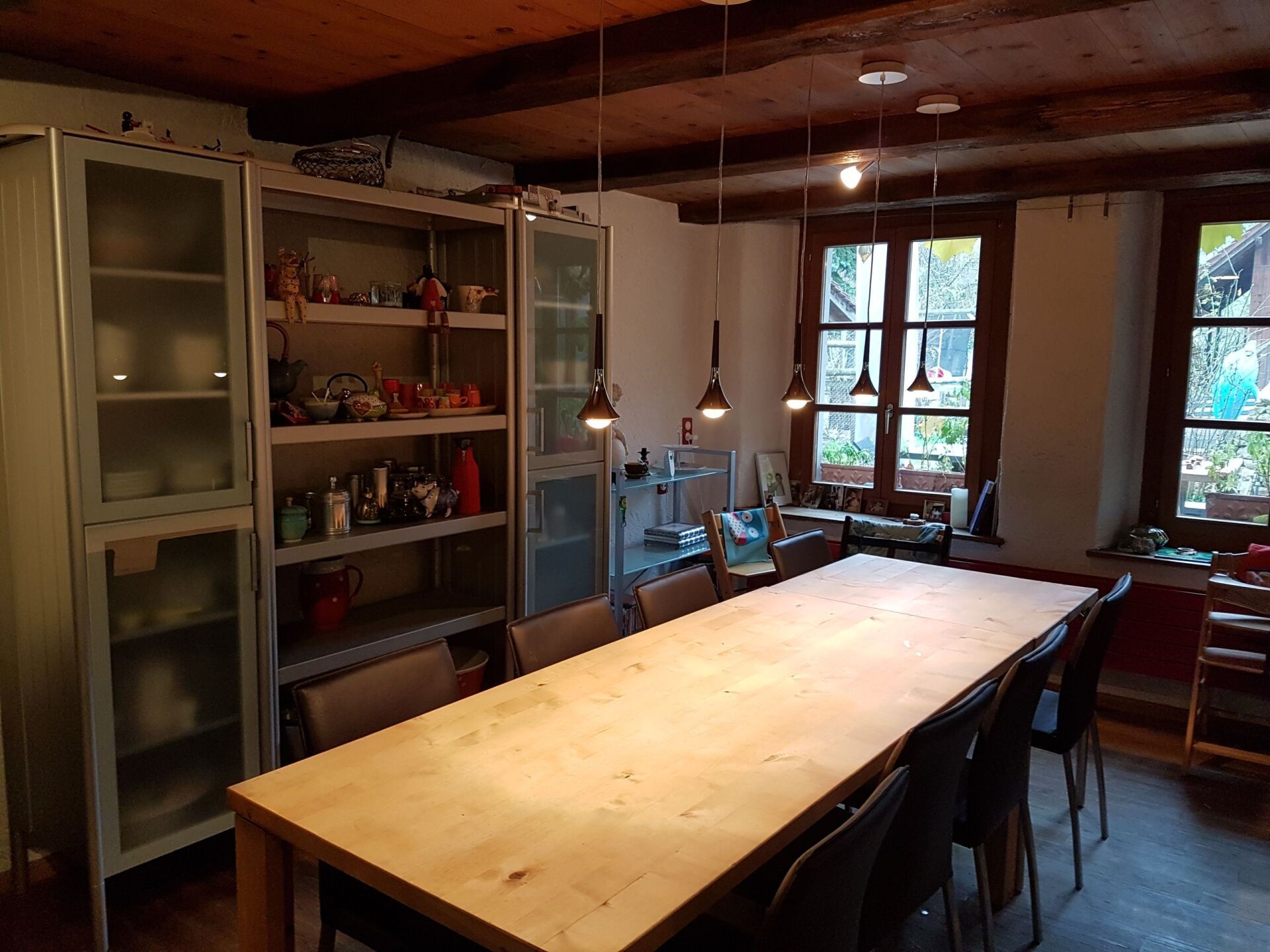 Ein Esszimmer mit einem langen Holztisch und Stühlen