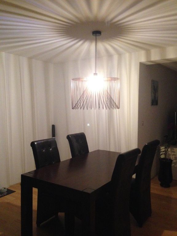 Ein Esszimmer mit Tisch und Stühlen unter einem Kronleuchter