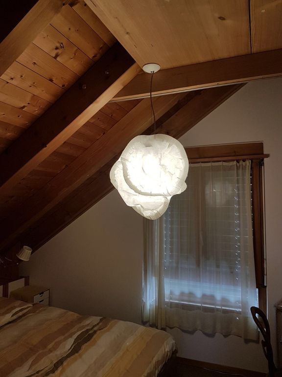 Ein Schlafzimmer mit einem Bett und einer von der Decke hängenden Lampe