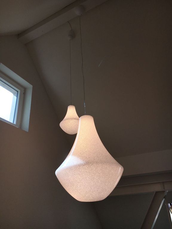 Zwei weiße Pendelleuchten hängen von der Decke