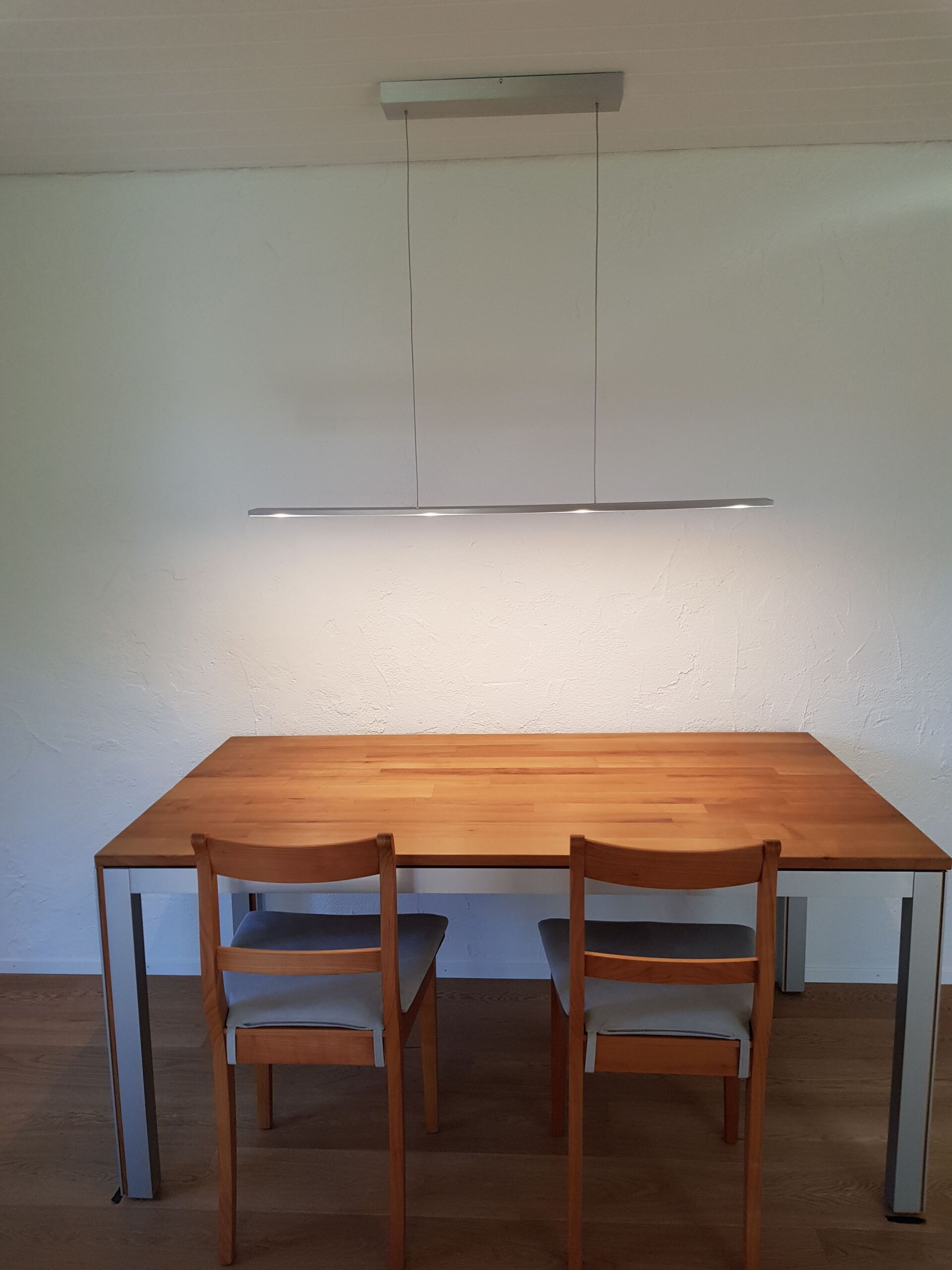 Ein Holztisch mit zwei Stühlen darunter