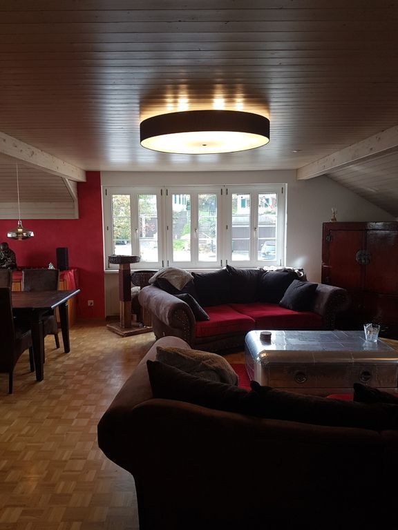 Ein Wohnzimmer mit einer roten Couch und einem Tisch