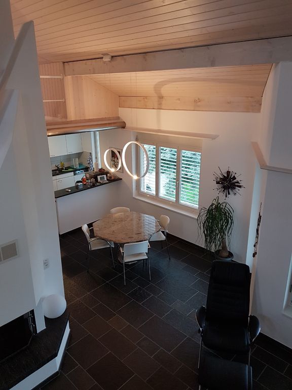 Eine Luftaufnahme eines Wohnzimmers mit einem Tisch und Stühlen.