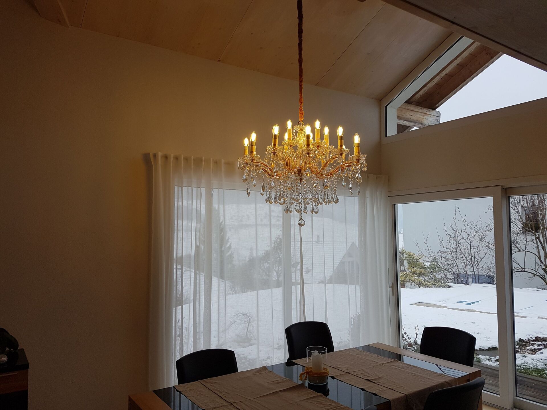 Ein Esszimmer mit Tisch und Stühlen und einem Kronleuchter, der von der Decke hängt.