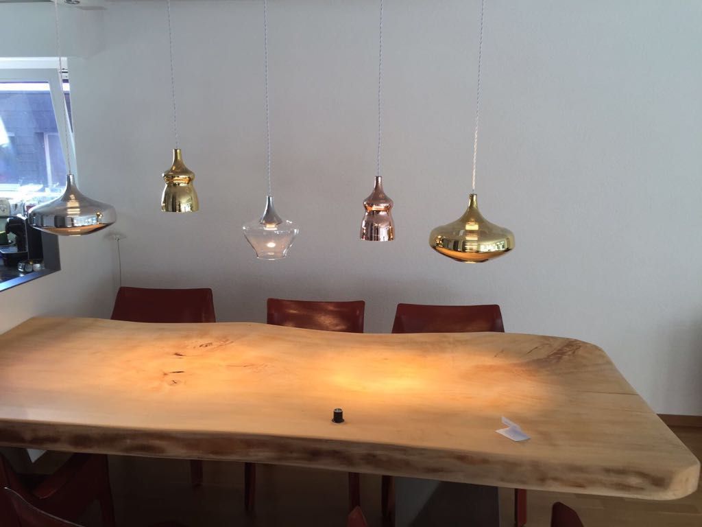 Ein Holztisch mit vielen Lichtern, die von der Decke hängen