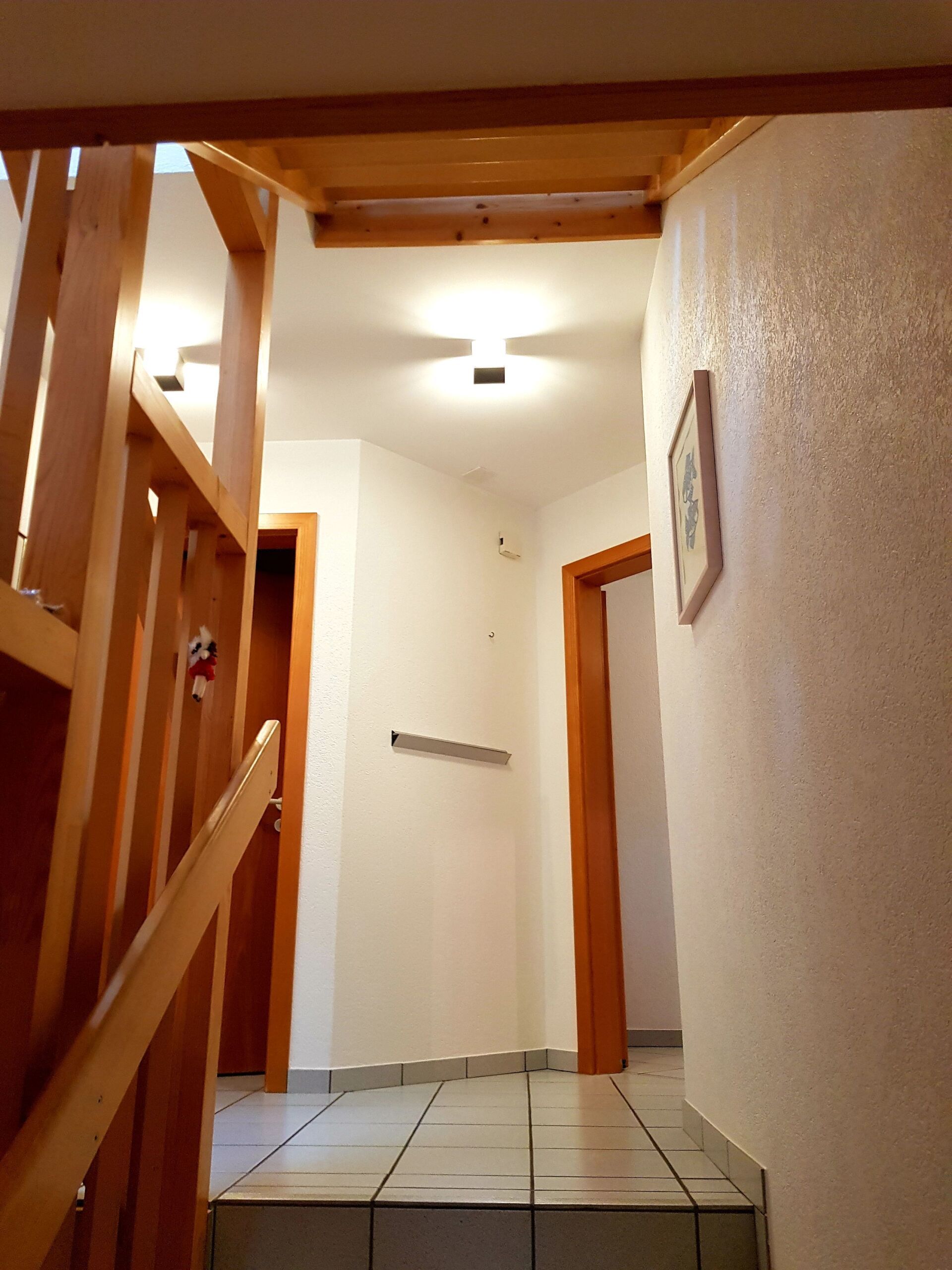 Ein Flur mit Treppe und einem Bild an der Wand