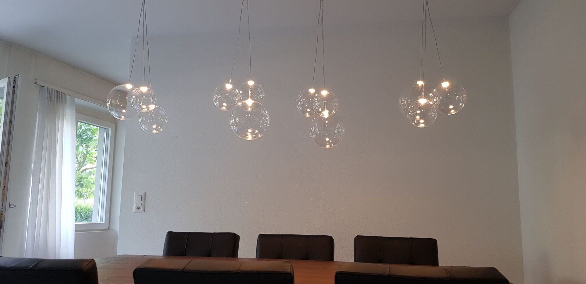 Ein Esszimmer mit Tisch und Stühlen und einem Kronleuchter, der von der Decke hängt.