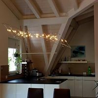 Eine Küche mit Esstisch und Stühlen und einem Kronleuchter, der von der Decke hängt.