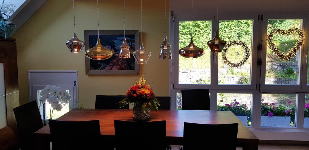 Ein Esszimmer mit einem Tisch und Stühlen und einer Vase mit Blumen auf dem Tisch.