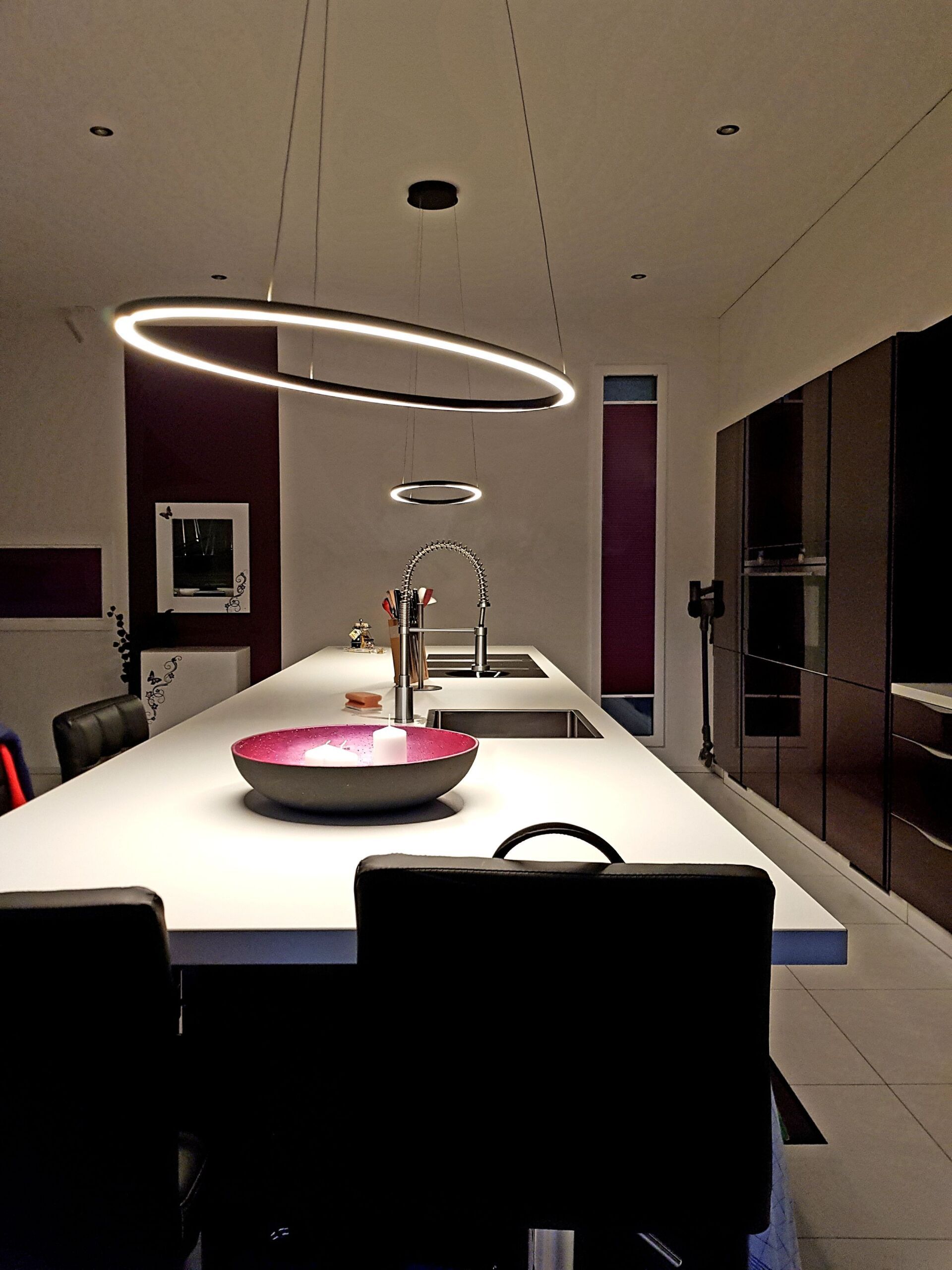 Eine Küche mit einem langen weißen Tisch und Stühlen