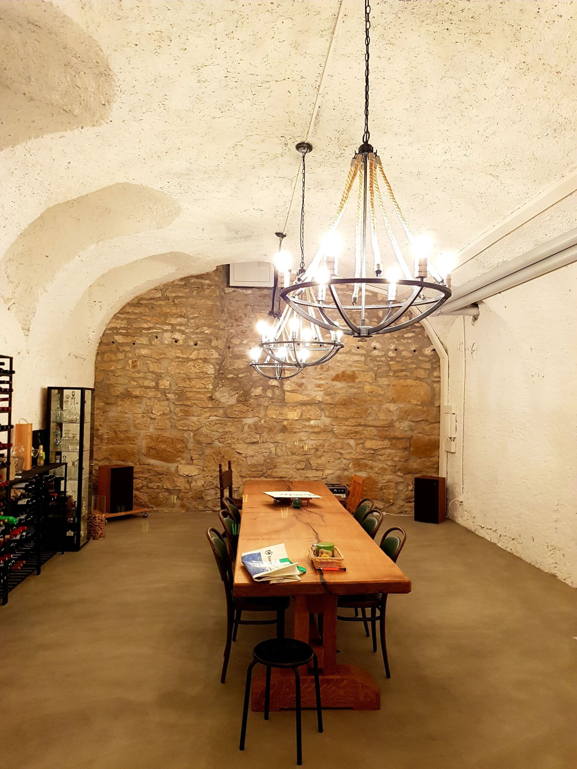 Ein Raum mit einem Tisch und Stühlen und einem Kronleuchter, der von der Decke hängt