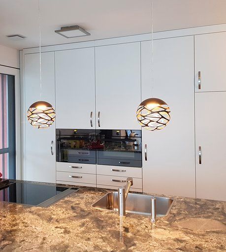 Eine Küche mit weißen Schränken, einer Spüle und einem Herd.