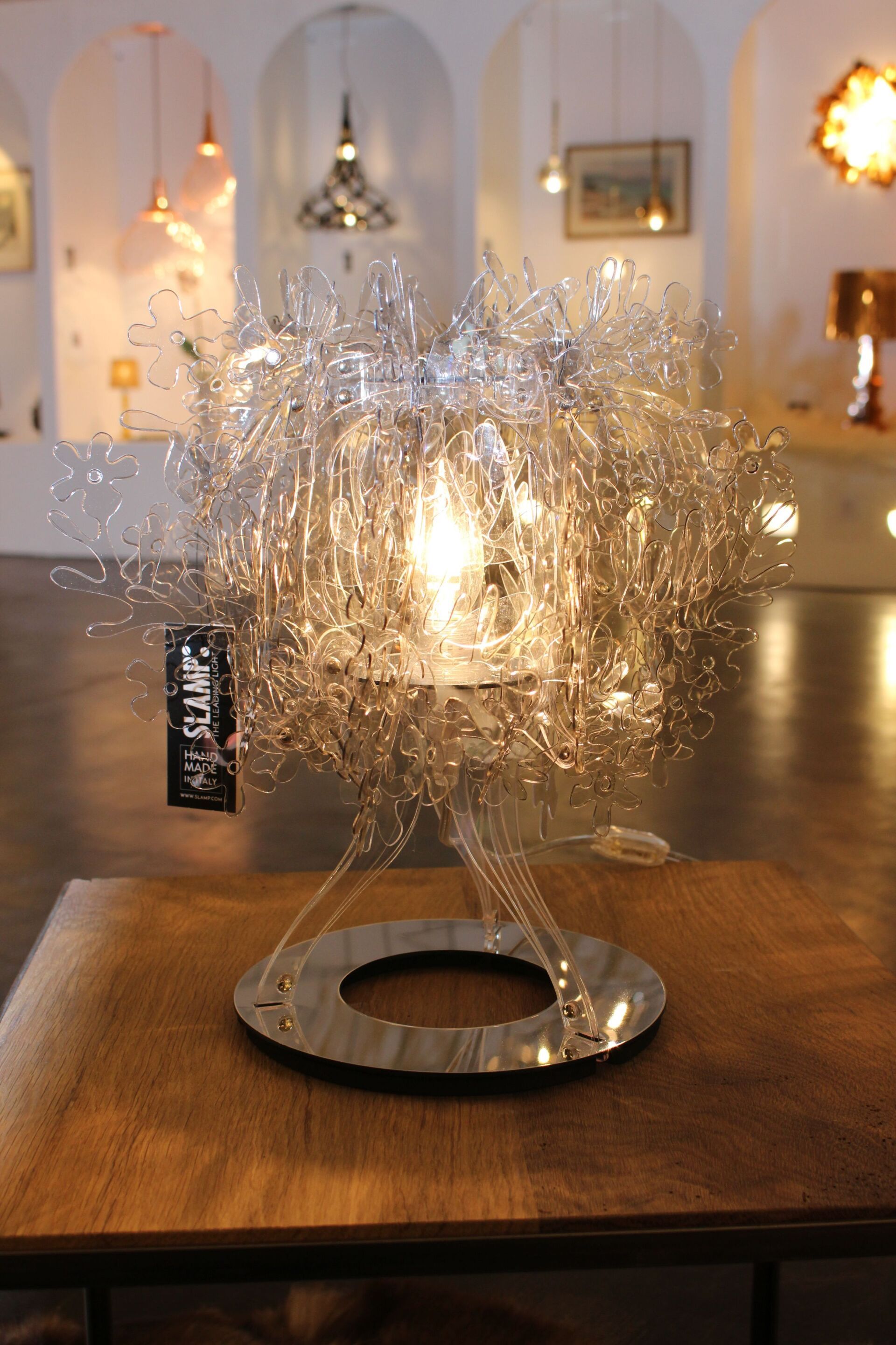 In einem Raum steht eine Lampe auf einem Holztisch.