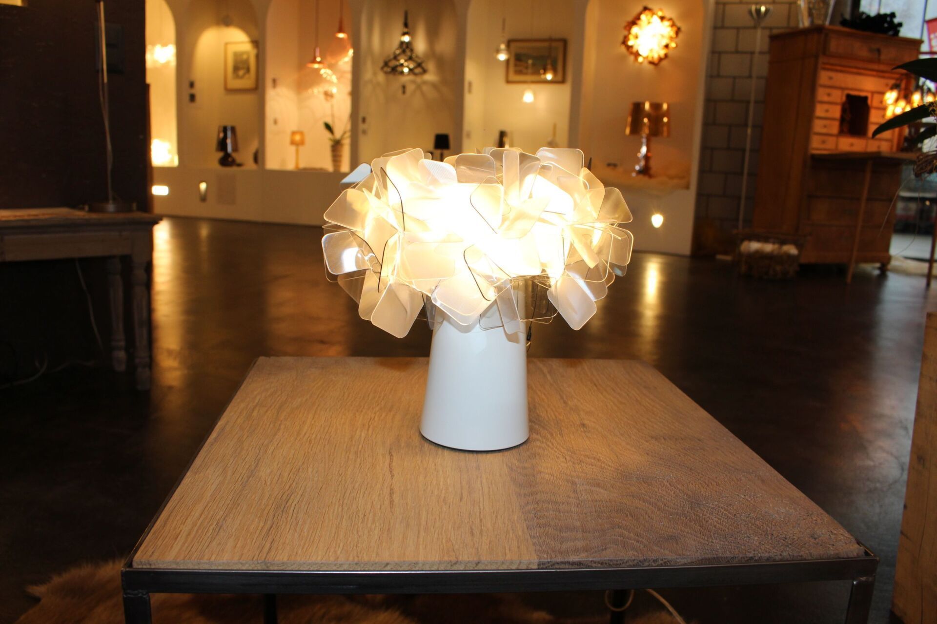 Auf einem Tisch steht eine weiße Vase mit einer Lampe darin.