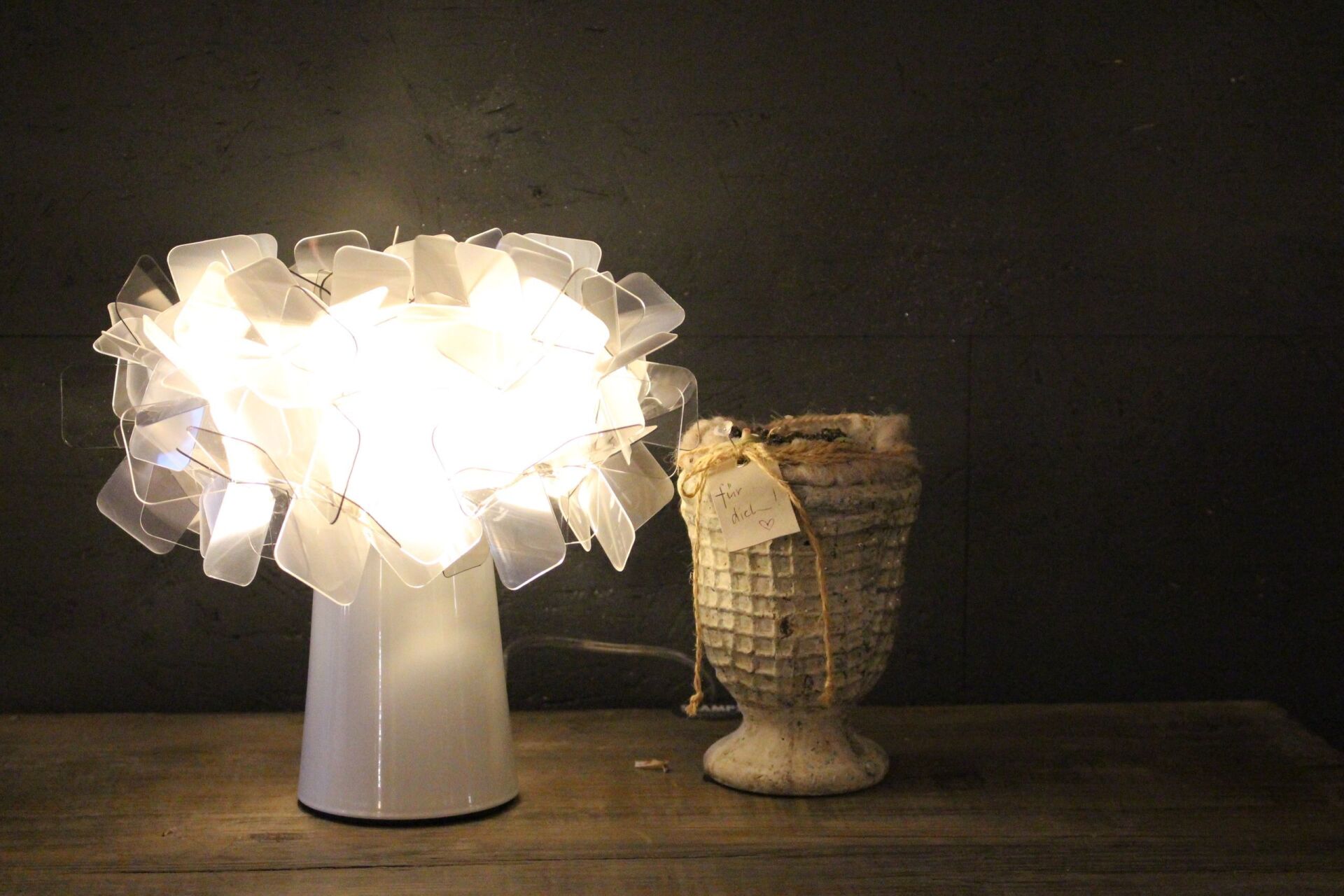 Ein Tisch mit einer Lampe und einer Vase darauf