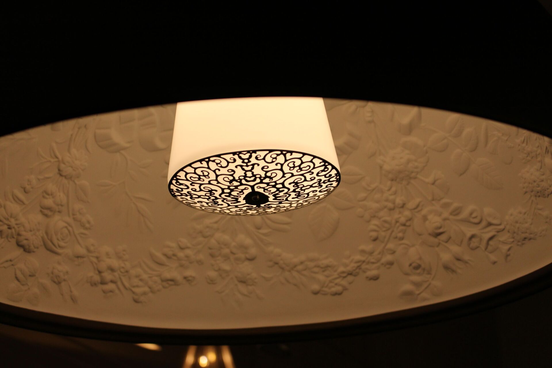 Von der Decke hängt eine Lampe mit weißem Schirm.