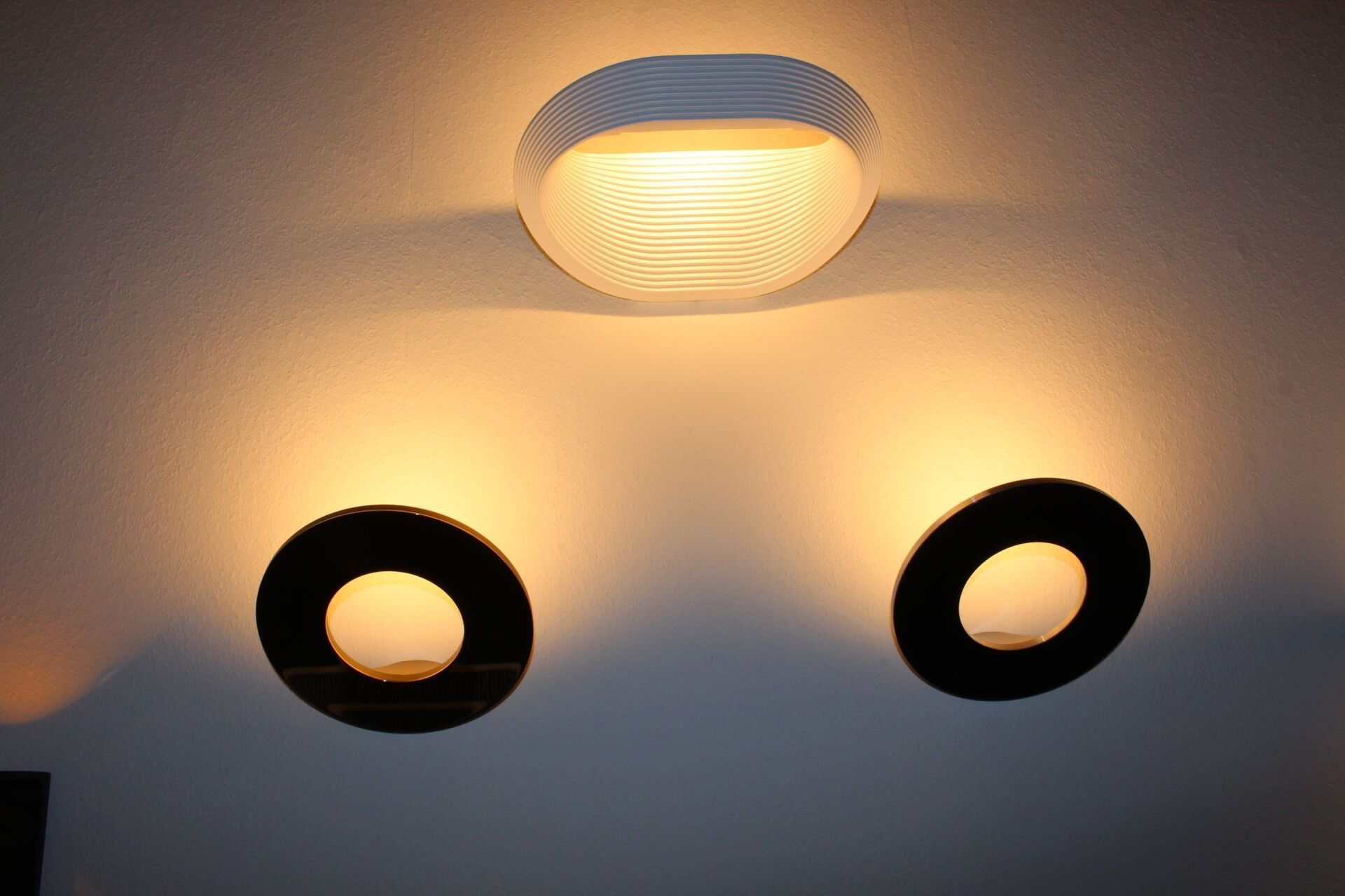Zwei Kreise leuchten an einer Wand, über ihnen ist ein Licht angebracht
